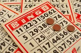 Bingo cards scattered on top of each other and 3 bingo tokens on different numbers