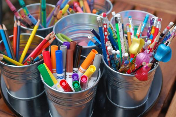 silver buckets filled with markers, colored pencils, and crayons