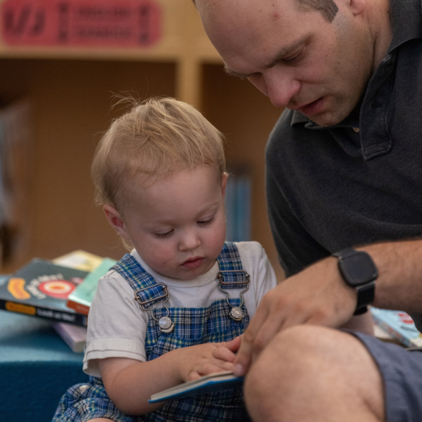 caregiver reads to a toddler