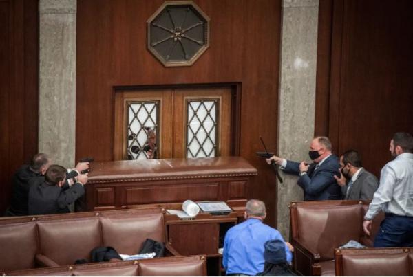  Security agents in the House chamber point their weapons after a mob stormed the Capitol building on Jan. 6, 2021. (Bill O'Leary/The Washington Post)