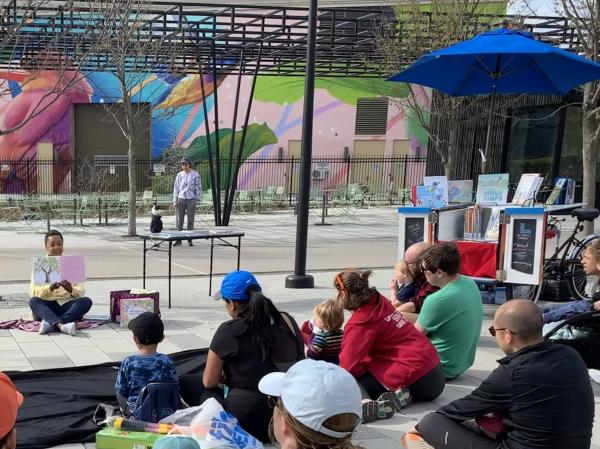 Library outreach staff hosting a story time for families in Alethia Tanner Park in NE DC