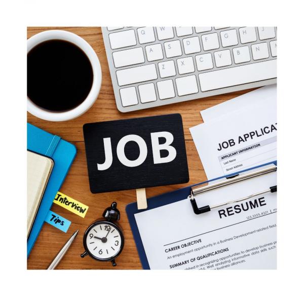 resume, job application, keyboard, coffee mug, clock and notebooks open on a desk