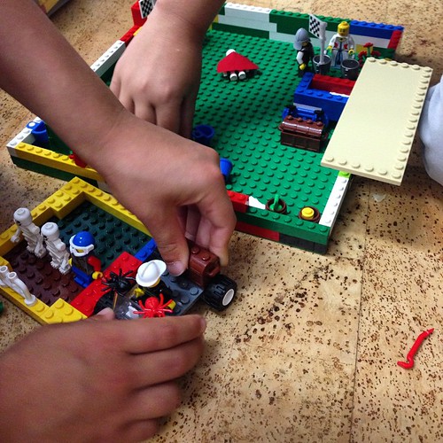 photo of three hands playing with LEGO