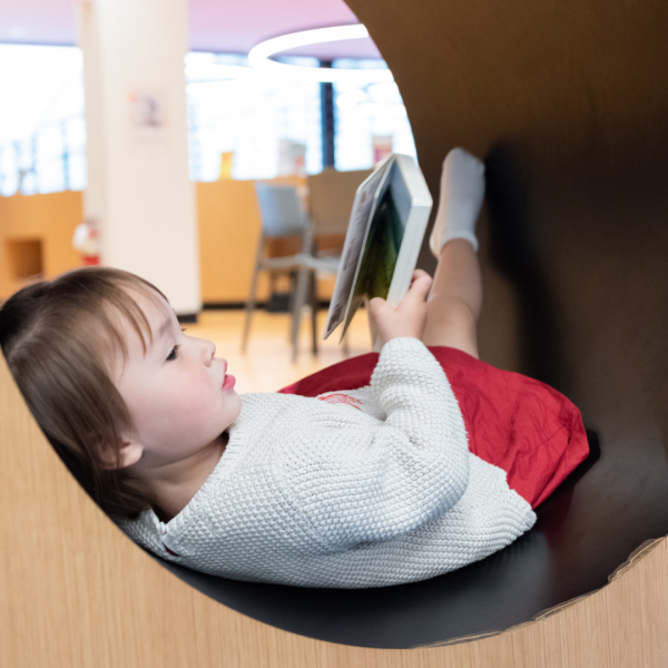 Child reading a book in a nook
