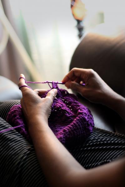 photo of two hands crocheting with purple yarn