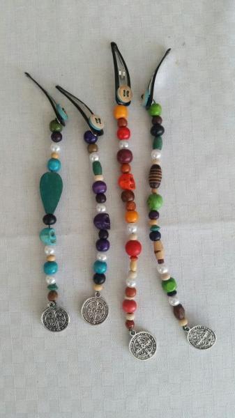 Four snap barrettes decorated with multiple colored beads and charms.