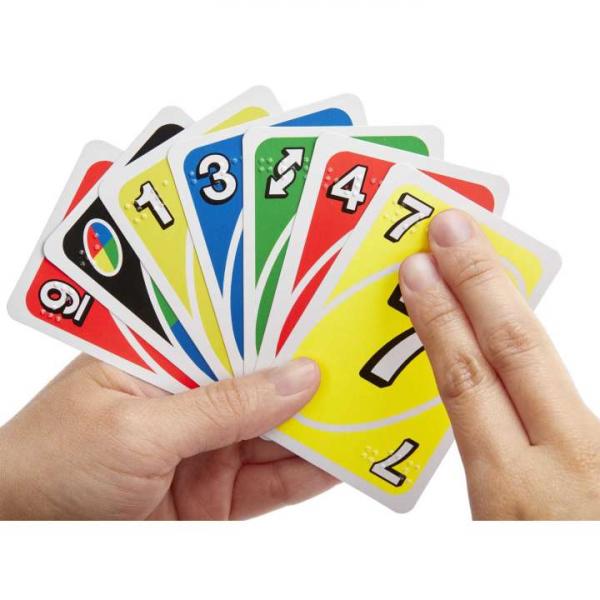 Hands holding colorful braille Uno cards