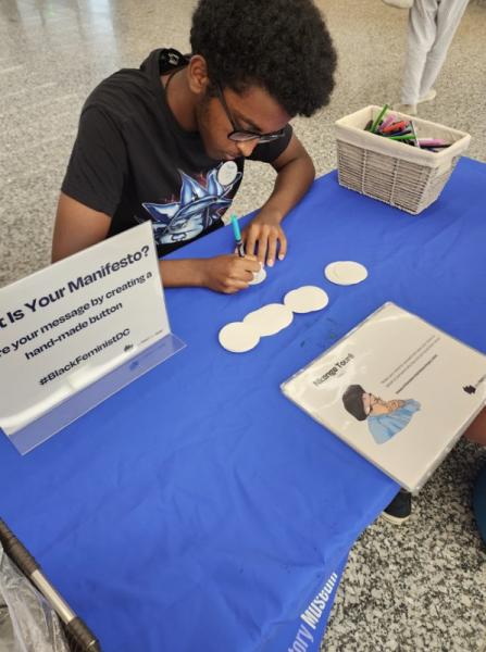 Volunteer makes buttons at the MLK Library