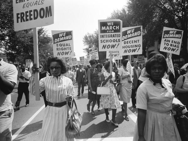 A black and white photograph of black women holding protest signs during a Civil Rights march.