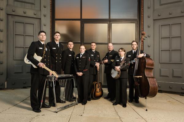 eight people in uniform stand with their instruments