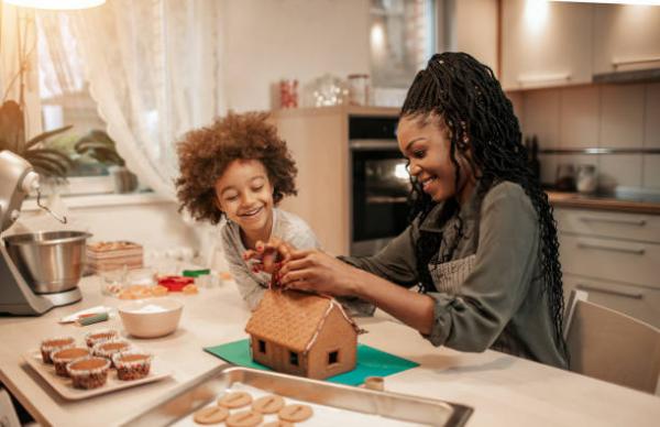 parent and child build a gingerbread house together