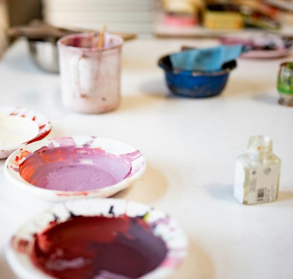 pink and red paint in small white bowls on a table