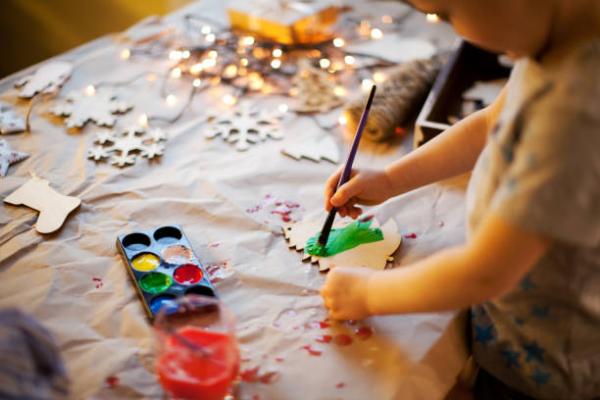 child creating a holiday ornament