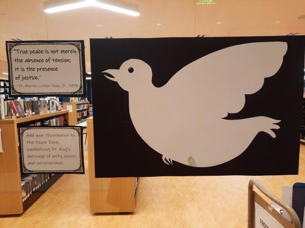 A photograph of a white peace dove on black construction paper, along with text from Dr. King, as well as craft instructions.