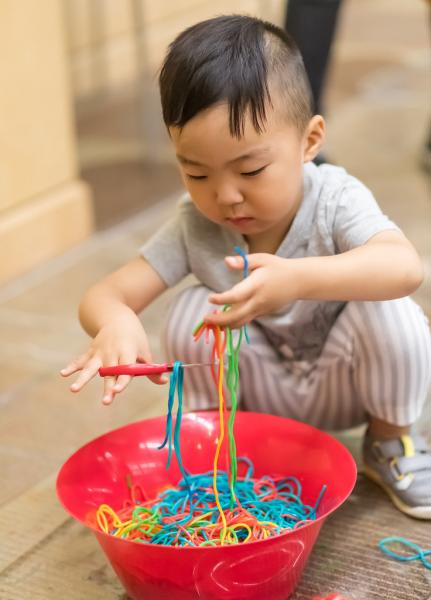 child cuts string in a bowl