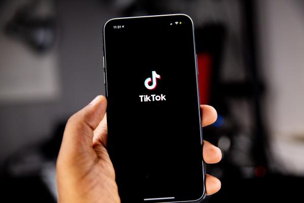 hand holding a phone showing the tiktok logo