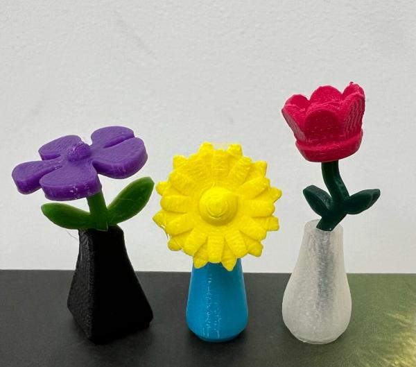 3D printed flowers in purple, yellow, and red
