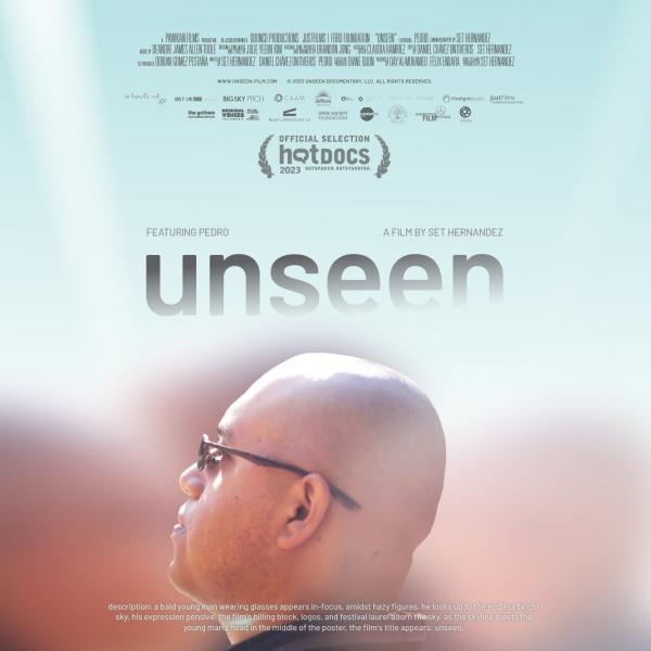 a bald young man wearing glasses appears in-focus, amidst hazy figures. he looks up to the endless bright sky, his expression pensive. the film's billing block, logos, and festival laurel adorn the sky. as the skyline meets the young man's head in the mid